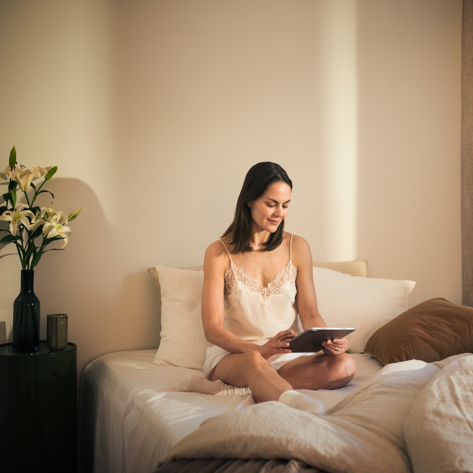 Woman in bedroom using a tablet
