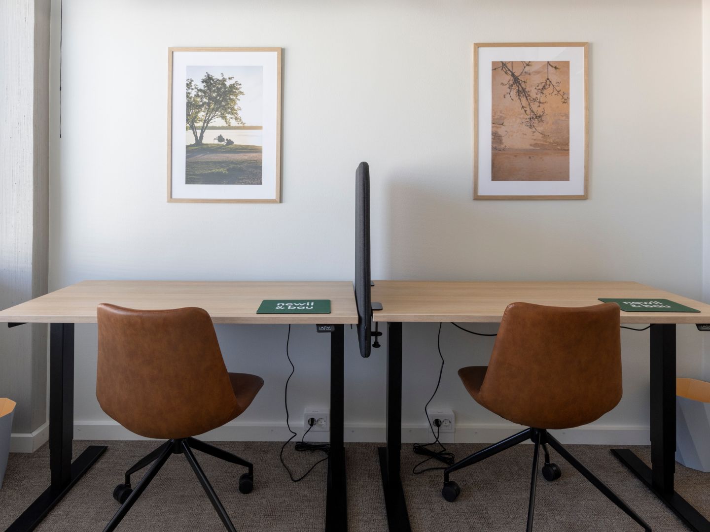 Kaksi etätyöpistettä tyylikkäillä kalusteilla.